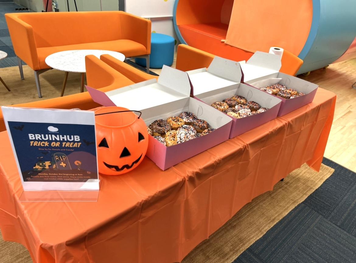 Table at the BruinHub with a candy bucket and donuts for Halloween