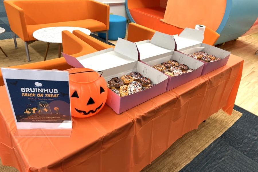 Table at the BruinHub with a candy bucket and donuts for Halloween